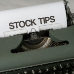 Old-fashioned typewriter displaying stock market tips, symbolizing retro finance advice.