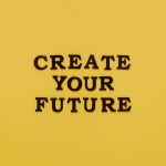 Bold text 'CREATE YOUR FUTURE' on minimalist yellow background. Inspiring design.