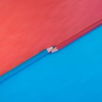 Abstract composition featuring red and blue pencils on contrasting red and blue backgrounds.