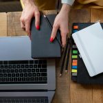 Top-down view of a desk with laptop, planner, and notebooks. Perfect for business and productivity themes.
