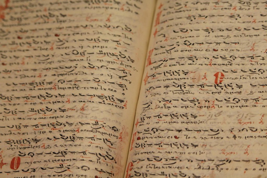 Close-up of an ancient manuscript with handwritten texts and ink inscriptions.